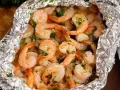 Juicy shrimp and tender potatoes cooked in foil packets in the oven, seasoned with herbs.