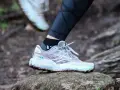 A Brooks Caldera trail running shoe on a rock, illustrating the heel drop for a runner.