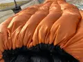 A bright orange sleeping bag with puffy baffles, ready for a cold night. This z pack 20 degree bag is perfect for camping adventures.