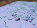 A topographic map of Zion Canyon shows elevation changes with contour lines, highlighting trails, visitor centers, and campgrounds.