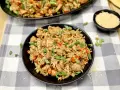 Chicken fried rice, a delicious dish perfect for learning how to cook rice on a Blackstone. Garnished with green onions and sesame seeds.
