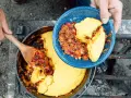 Serving hearty chili and cornbread from a Dutch oven over a campfire. This is easy camp food at its finest.