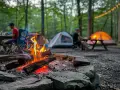 A crackling campfire sets the scene for a large group camping trip. Tents glow in the twilight as friends gather around picnic tables in the woods.