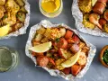 Foil packets filled with shrimp, sausage, corn, and potatoes. These are perfect for easy camping meals, served with lemon wedges and melted butter.