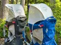 Two Osprey Poco Plus child carriers in black and blue, ready for adventure. Check the Osprey Poco Plus weight limit for safe hiking.