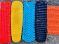 Five camping sleeping pads in red, yellow, blue, black, and orange. The black Nemo Tensor is the quietest sleeping pad for a peaceful night's sleep.
