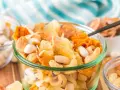 A delicious tropical trail mix recipe with cashews, dried pineapple, and coconut flakes in a glass bowl.