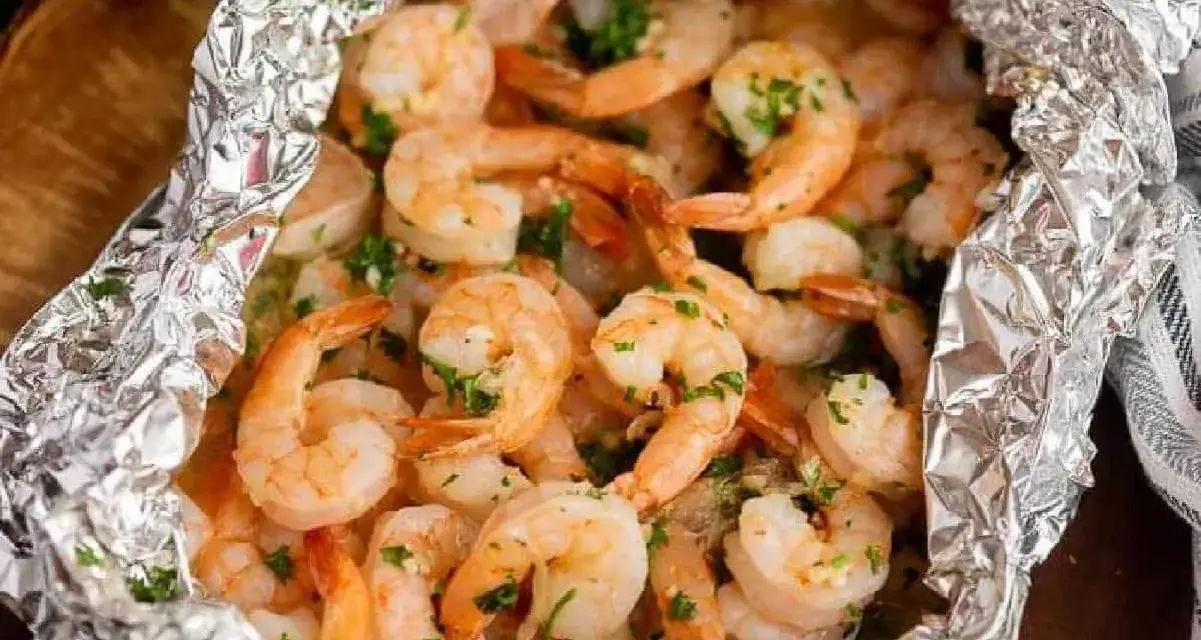Juicy shrimp and tender potatoes cooked in foil packets in the oven, seasoned with herbs.