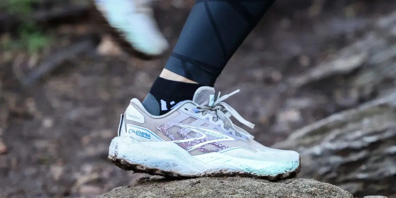 A Brooks Caldera trail running shoe on a rock, illustrating the heel drop for a runner.