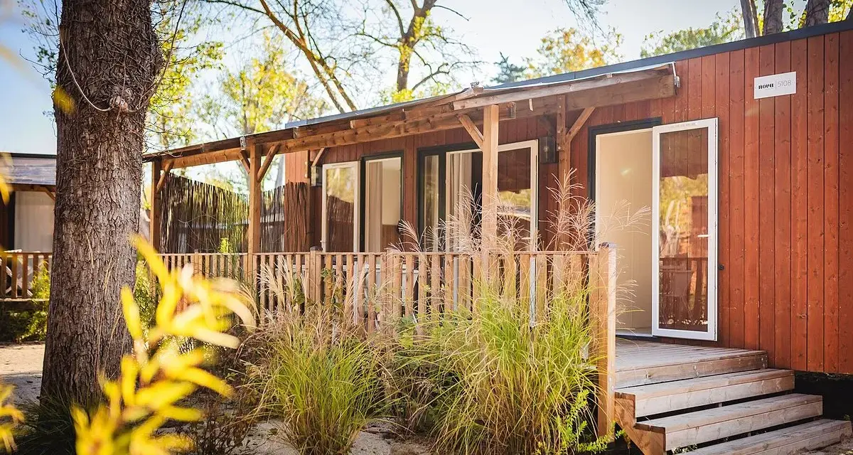 A charming mobil home in the Var region, with a wooden deck and lush greenery.