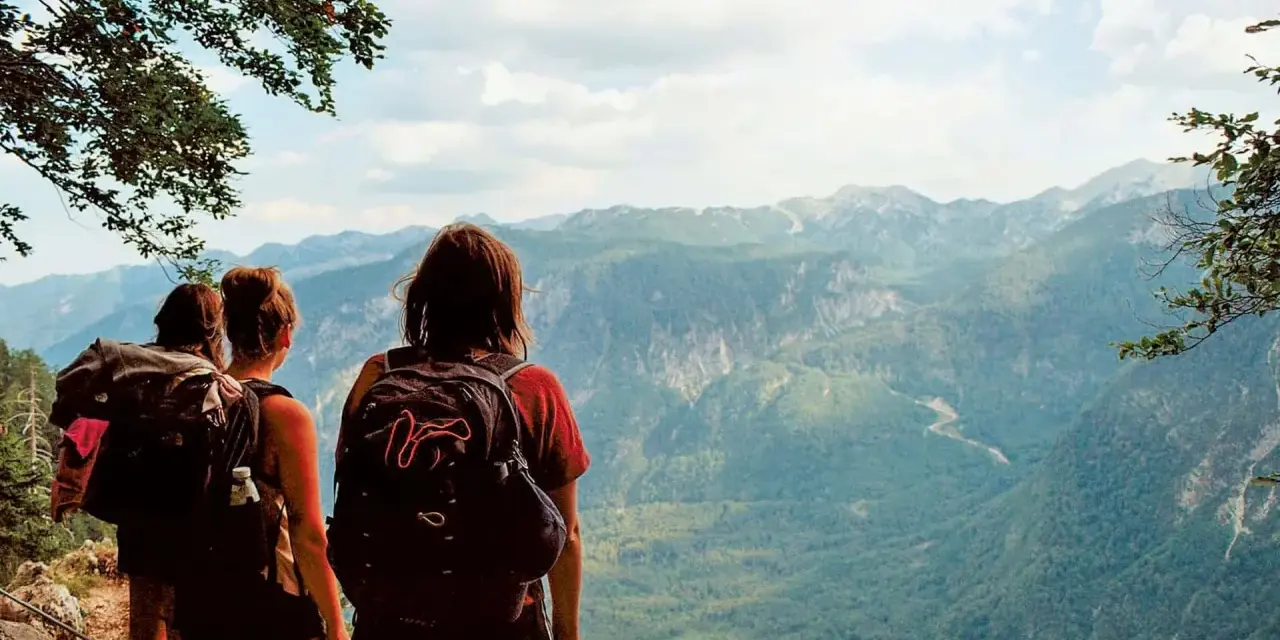Hikers pause on a pyrenees trail, taking in the breathtaking mountain vista.