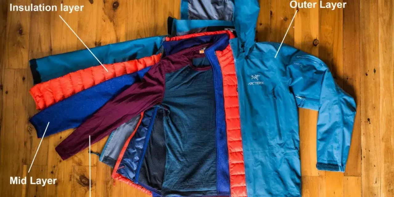 Demonstration of how to layer for hiking: base layer, mid layer, insulation layer, and outer layer.