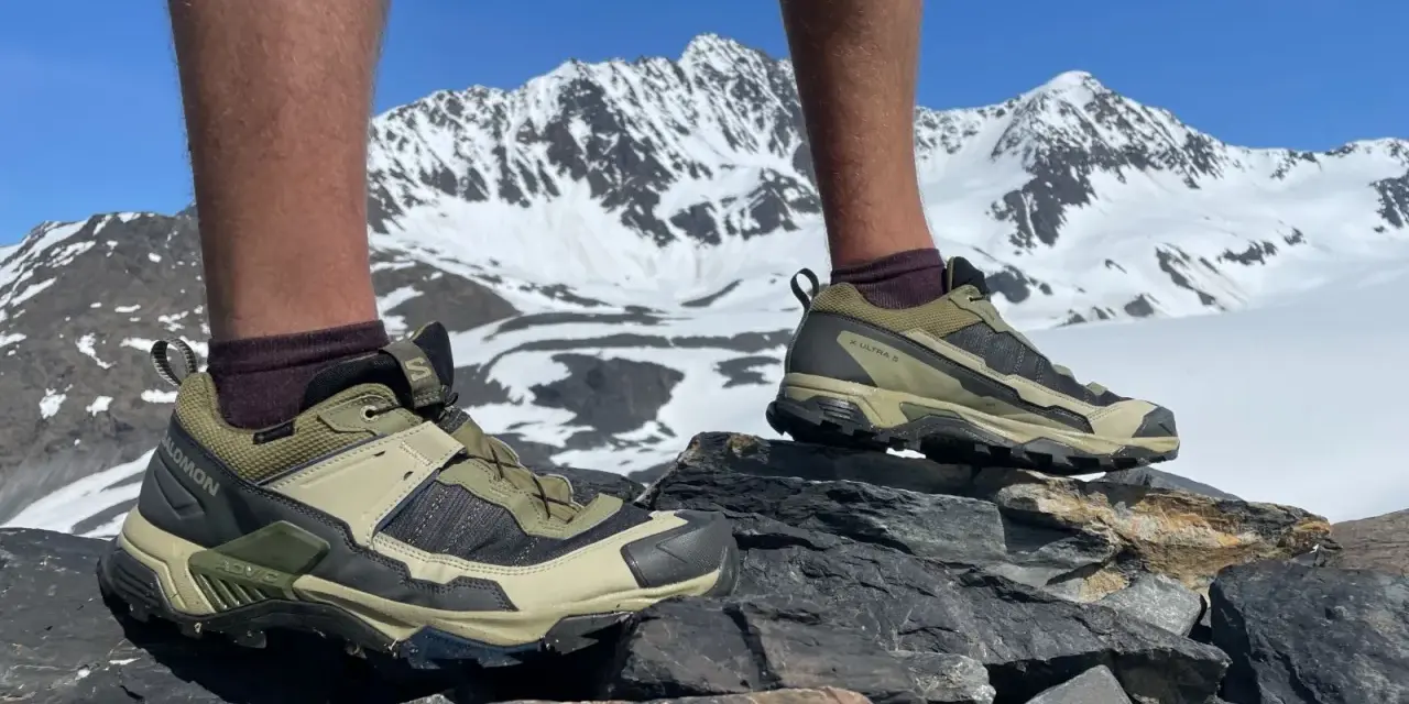 Salomon X Ultra 5 GTX shoes on rocky terrain with snowy mountains in the background. Ready for any adventure.