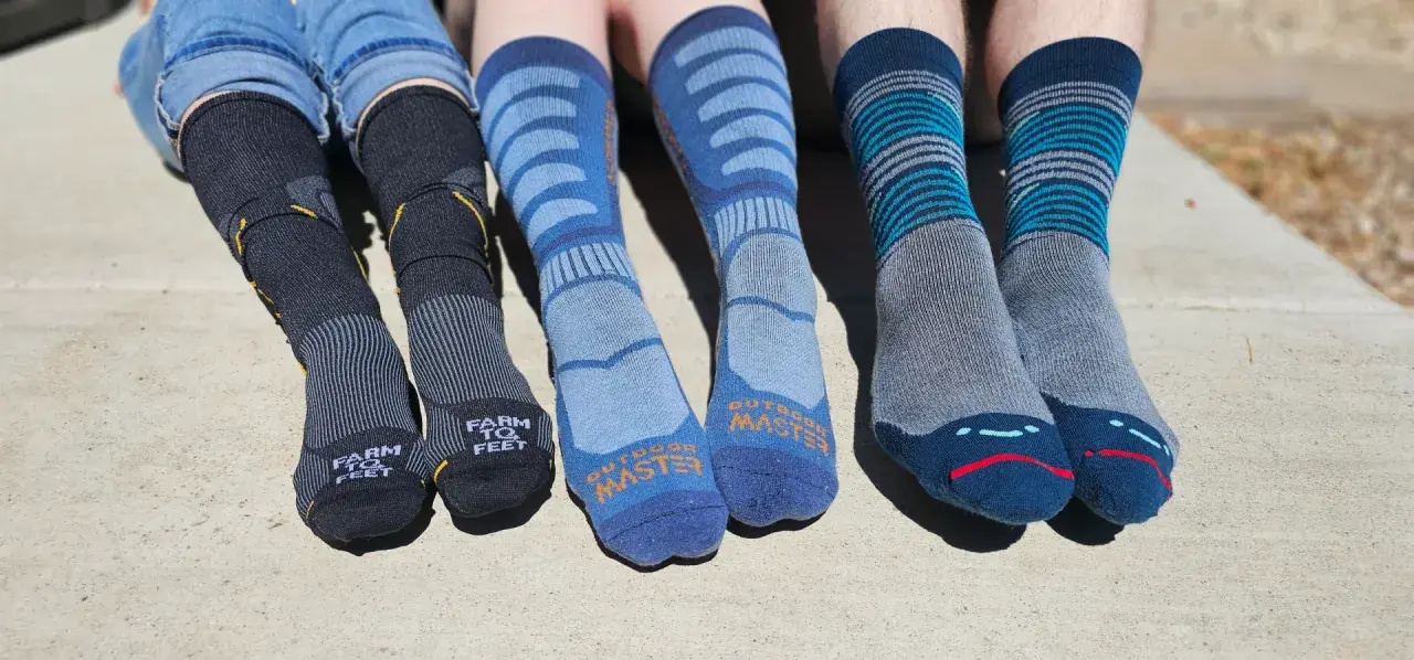 Four pairs of colorful hiking socks, some with stripes, others with logos, ready for adventure.