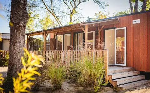 A charming mobil home in the Var region, with a wooden deck and lush greenery.