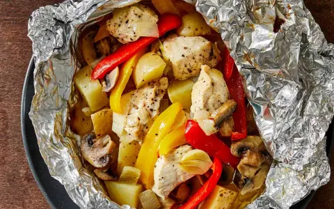 Chicken, potatoes, peppers, and mushrooms cooked in foil. Wondering how long to cook tin foil dinners in fire for this delicious meal?