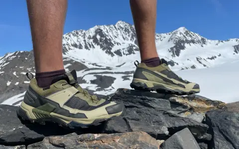 Salomon X Ultra 5 GTX shoes on rocky terrain with snowy mountains in the background. Ready for any adventure.