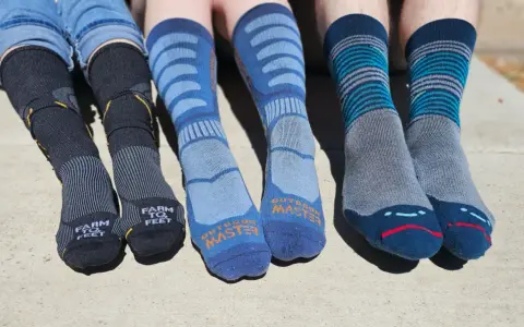 Four pairs of colorful hiking socks, some with stripes, others with logos, ready for adventure.