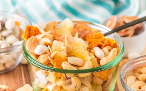 A delicious tropical trail mix recipe with cashews, dried pineapple, and coconut flakes in a glass bowl.