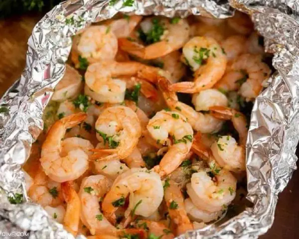 Juicy shrimp and tender potatoes cooked in foil packets in the oven, seasoned with herbs.