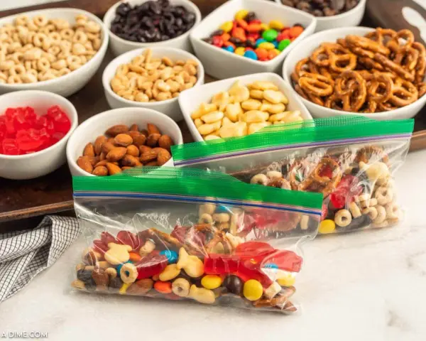 Bags of colorful trail mix bar ingredients: cereal, nuts, pretzels, candy, and dried fruit, ready for snacking.