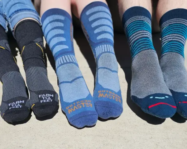 Four pairs of colorful hiking socks, some with stripes, others with logos, ready for adventure.