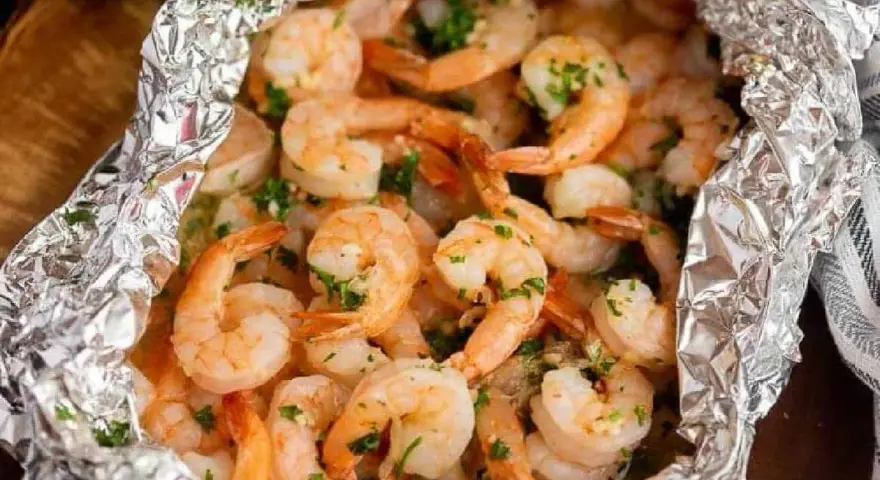 Juicy shrimp and tender potatoes cooked in foil packets in the oven, seasoned with herbs.