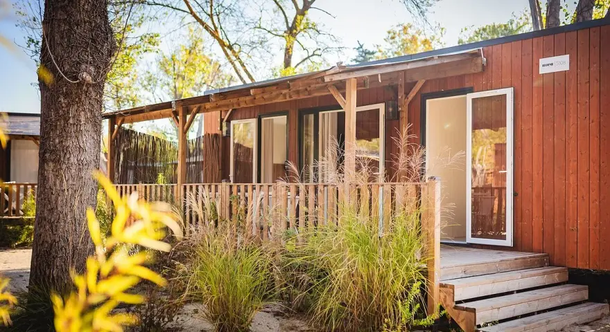 A charming mobil home in the Var region, with a wooden deck and lush greenery.