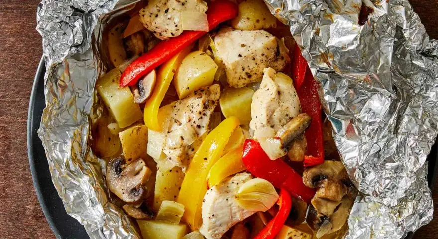 Chicken, potatoes, peppers, and mushrooms cooked in foil. Wondering how long to cook tin foil dinners in fire for this delicious meal?