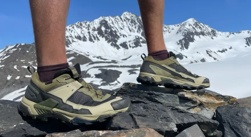 Salomon X Ultra 5 GTX shoes on rocky terrain with snowy mountains in the background. Ready for any adventure.