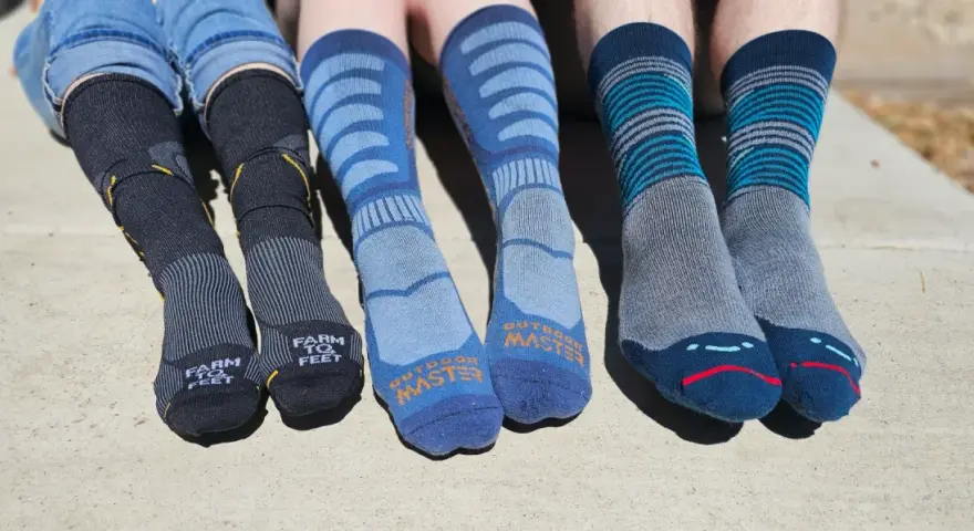 Four pairs of colorful hiking socks, some with stripes, others with logos, ready for adventure.