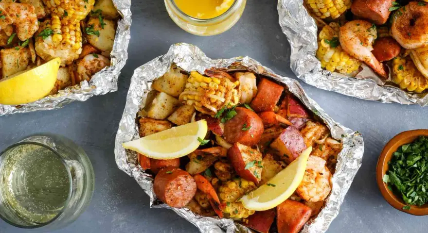 Foil packets filled with shrimp, sausage, corn, and potatoes. These are perfect for easy camping meals, served with lemon wedges and melted butter.