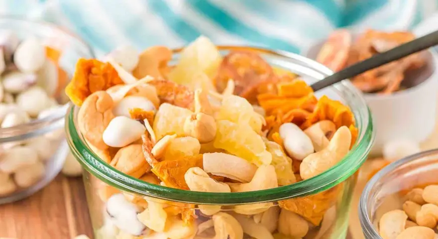 A delicious tropical trail mix recipe with cashews, dried pineapple, and coconut flakes in a glass bowl.