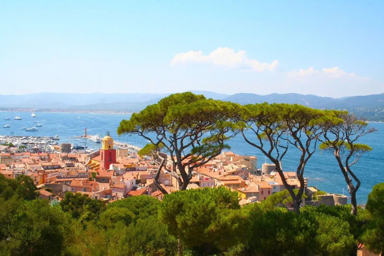 Scenic view of Saint-Tropez, France, with its iconic red-domed church and bustling harbor. Imagine a perfect camping 3 &eacute;toiles var getaway with this view!