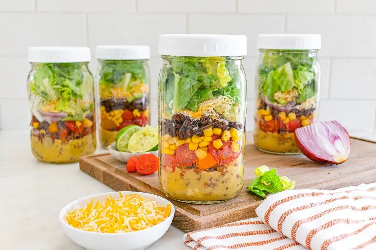 Perfect for camping, these layered mason jar salads are packed with fresh ingredients.