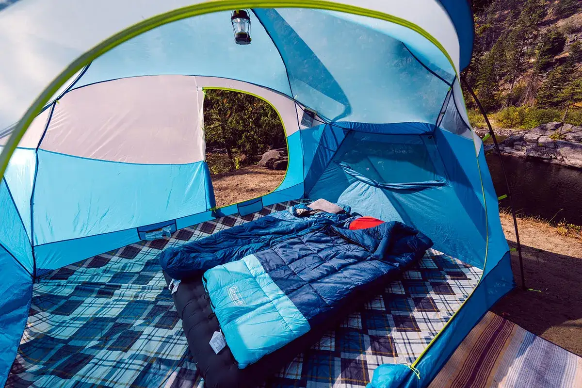 Inside a blue tent, two sleeping bags await adventure. The Nemo Aurora tent is ready for a night under the stars.