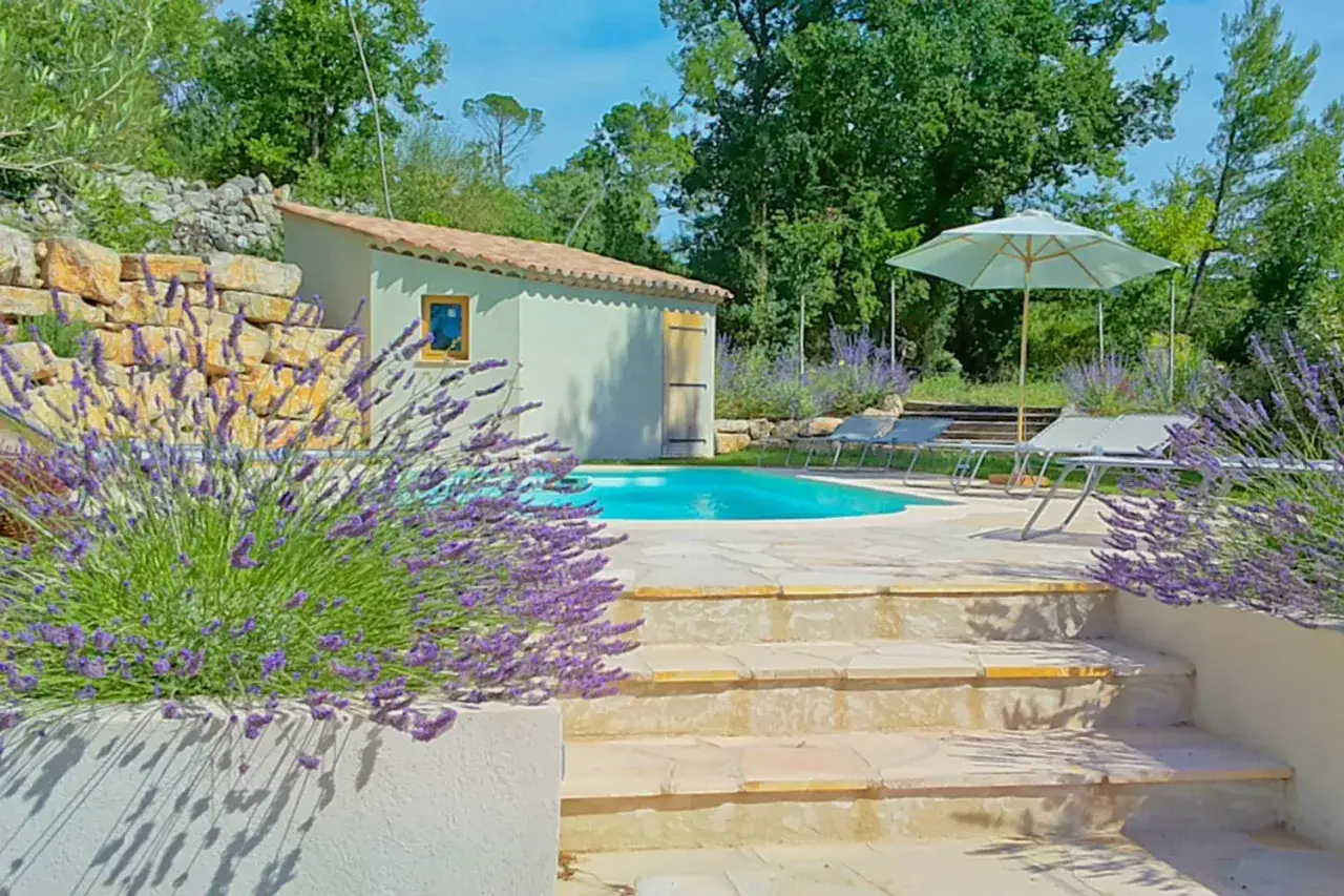 A serene vakantiepark Provence scene with a pool, sun loungers, and blooming lavender.