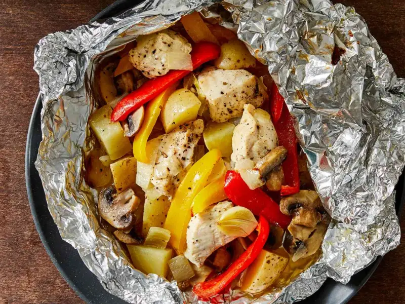 Chicken, potatoes, peppers, and mushrooms cooked in foil. Wondering how long to cook tin foil dinners in fire for this delicious meal?